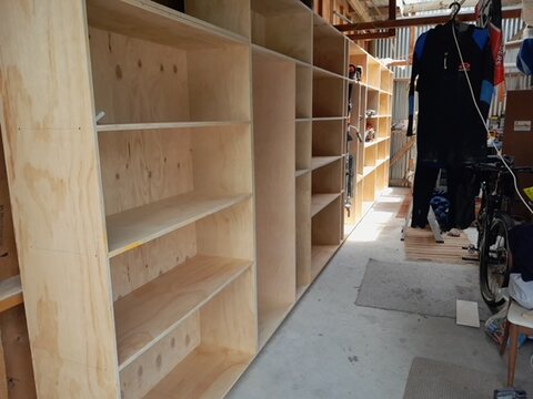 Plywood storage shelving being built along the wall