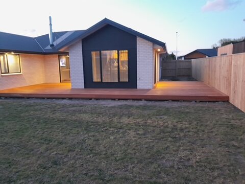Gable end of the finished home with dark cladding and brick detailing