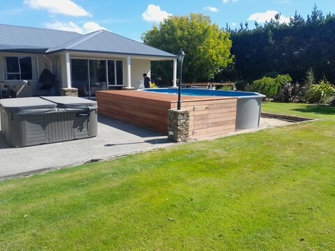 Hardwood pool surround and spa deck alongside a covered outdoor living area