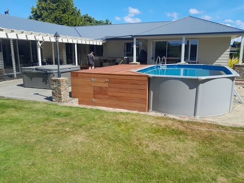Pool, spa and deck seen from across the lawn