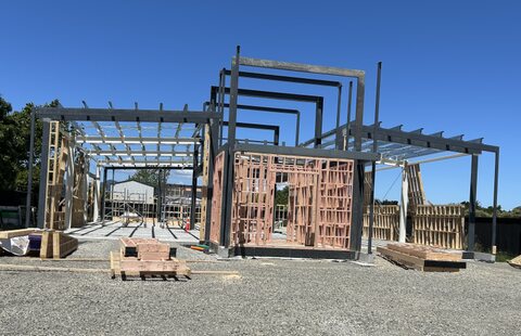 Large timber and steel frame standing on a new concrete pad