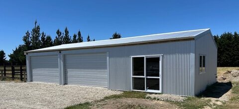Two-bay shed with roller doors and a window on a rural section